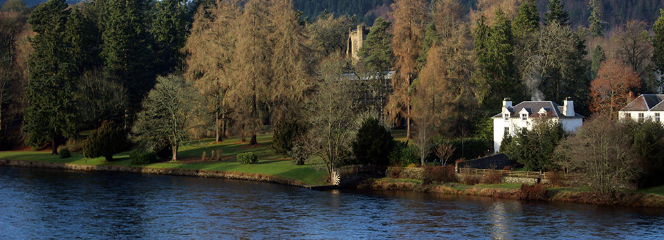 Dunkeld 2 A scenic view across the river tay toward a white country house situated on the edge of a dense forest in Dunkeld, Scotland.