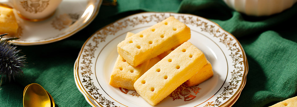 Shortbread-2 Traditional rectangular shortbread biscuits stacked on an ornate white and gold plate.